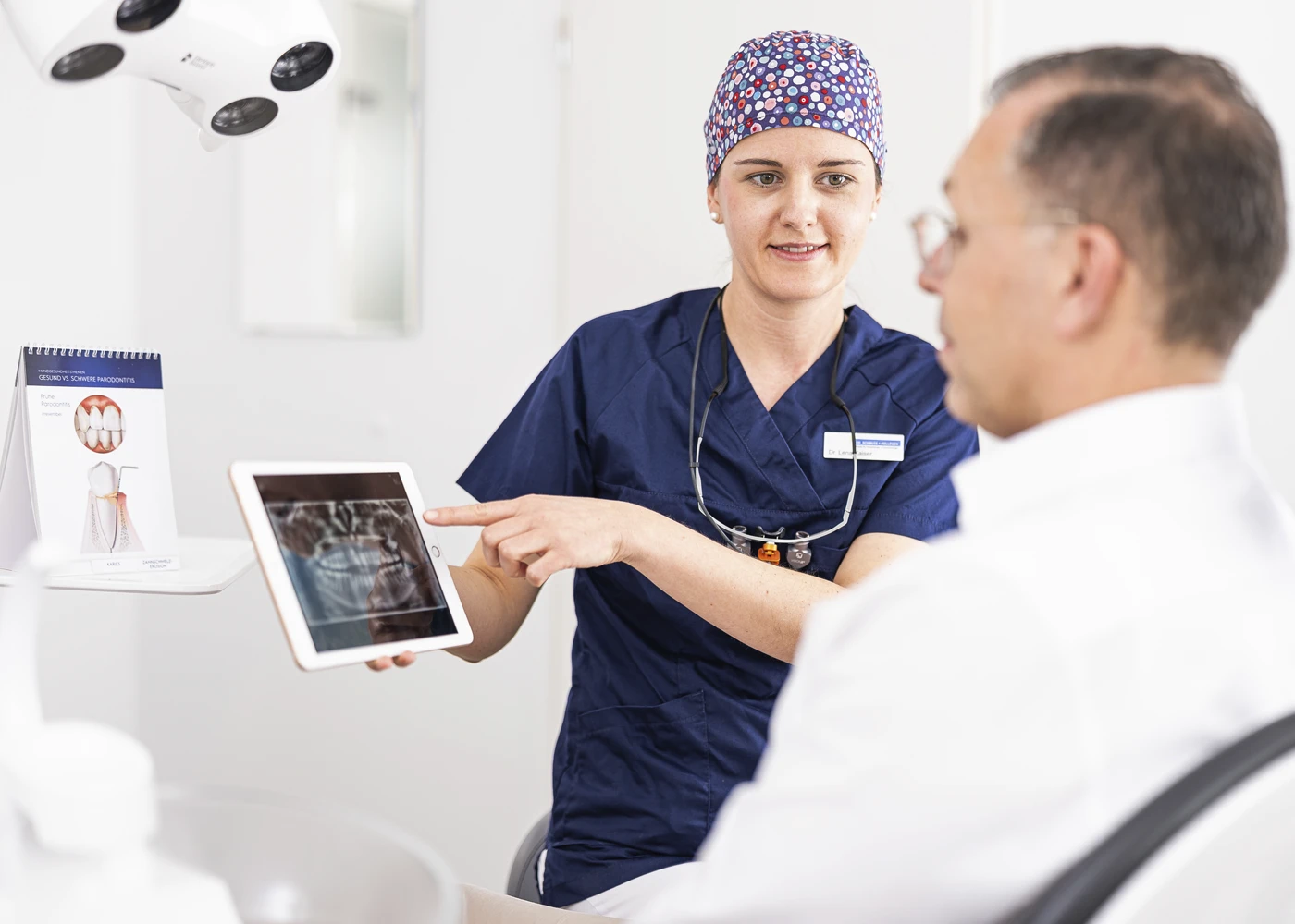 Zahnärztin erklärt Röntgenaufnahme einem Patienten in der Praxis Dr. Schmutz.
