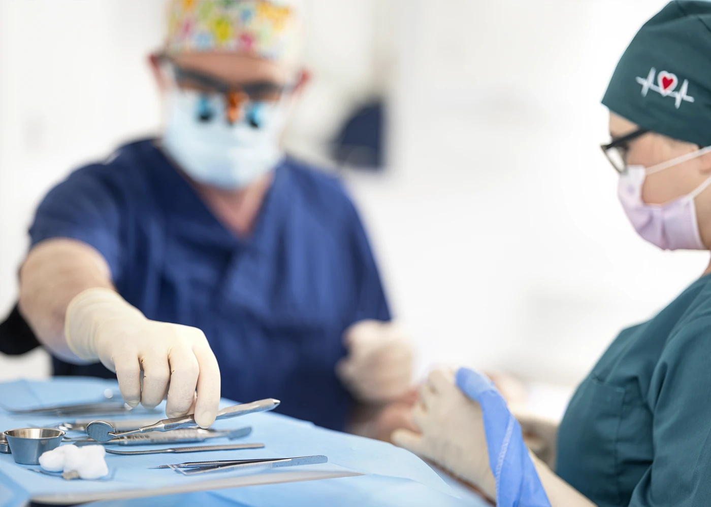 Zahnarzt Dr. Schmutz bei der Arbeit mit Fokus auf sterile Zahn-Instrumente.