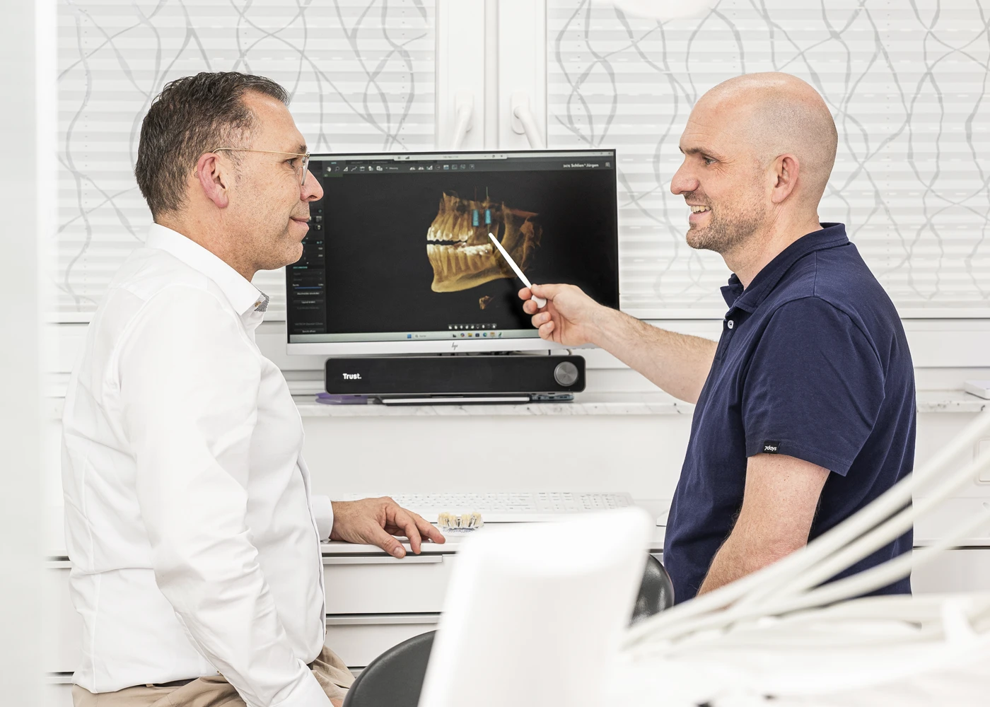 Zahnarzt berät Patienten anhand eines 3D-Bildes im Praxis Dr. Schmutz, Villingen-Schwenningen.