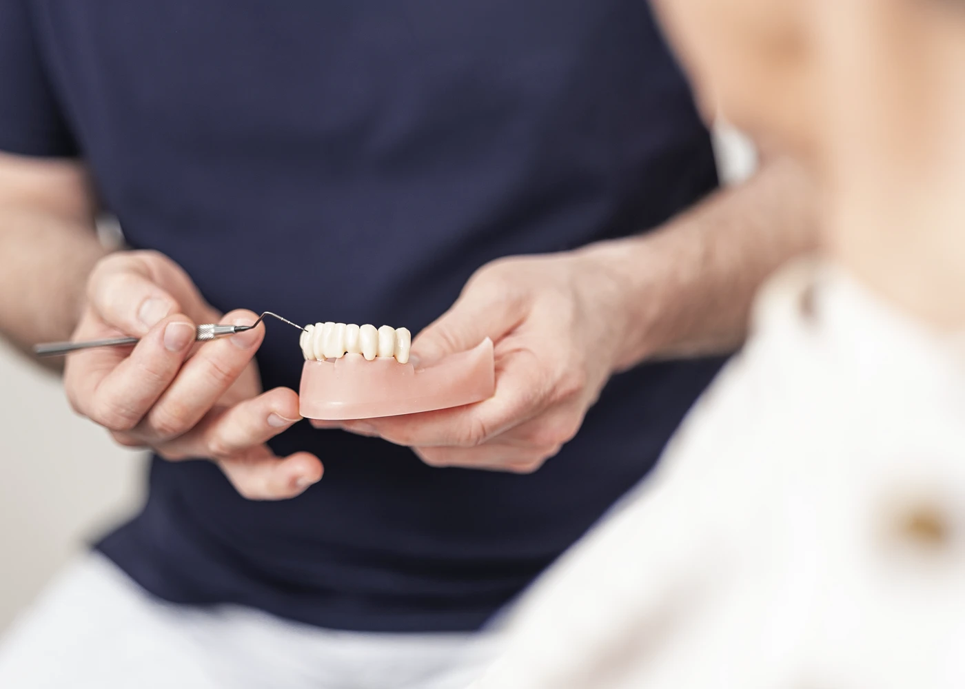 Ein Zahnarzt demonstriert Zahnprothese mit einem Modell in der Praxis Dr. Schmutz.