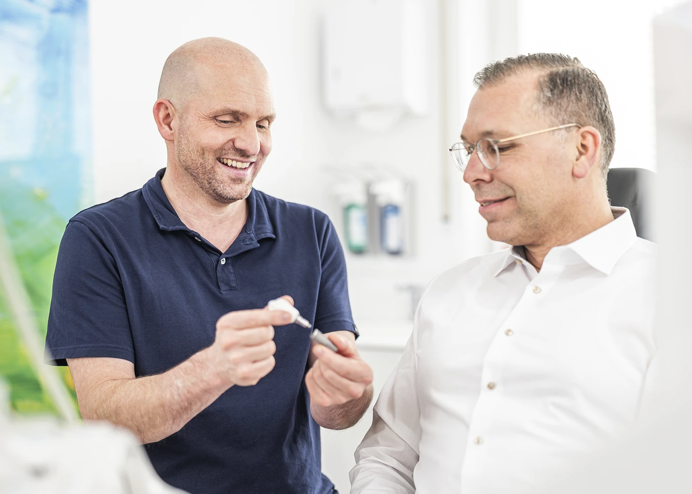 Dr. Schmutz erklärt einem Patienten ein Zahnmodell in der Zahnarztpraxis Villingen-Schwenningen.